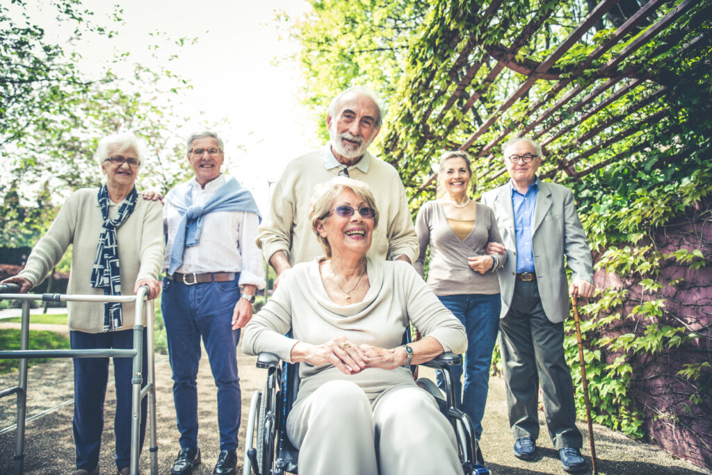 Group of senior people with some diseases walking outdoors - Mature group of friends spending time together